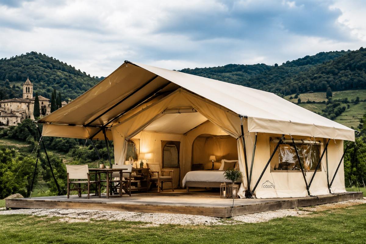 A luxury glamping tent set up in a scenic European countryside site, showing high-quality weatherproof PVC fabric