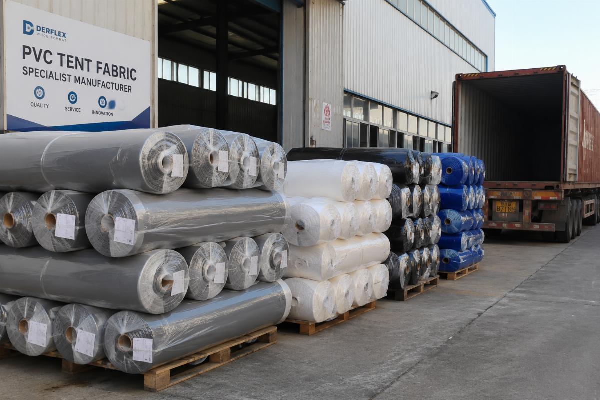 Bulk rolls of PVC tent fabric ready for shipping at a factory loading dock