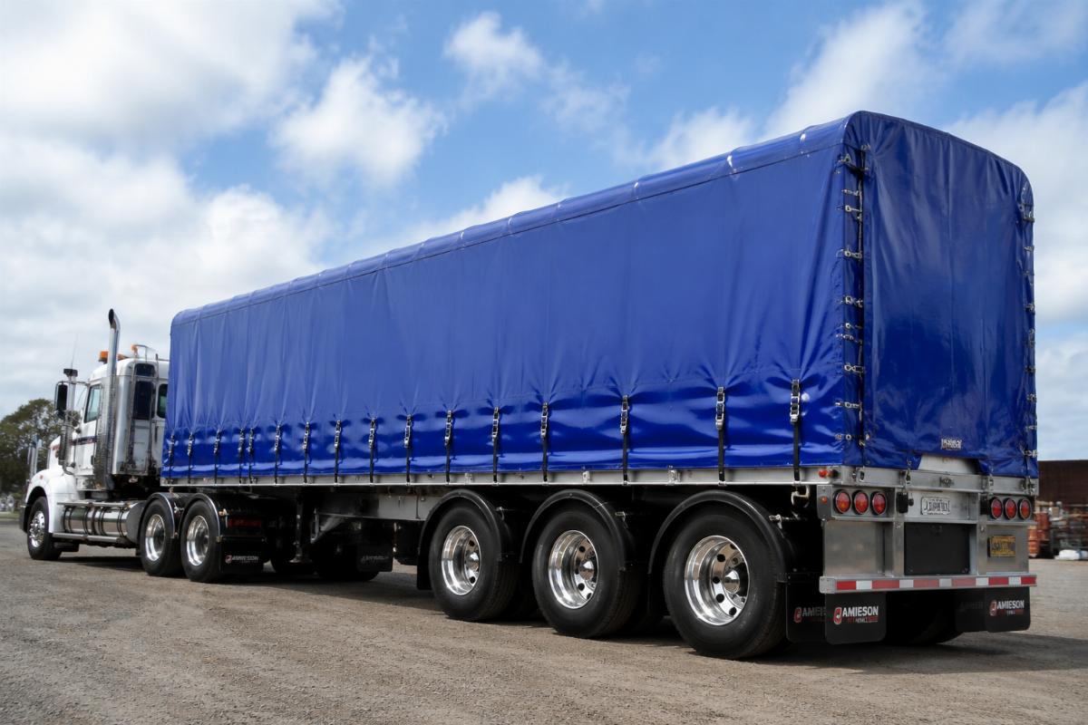 Custom fitted PVC truck tarp installed on a heavy haul truck