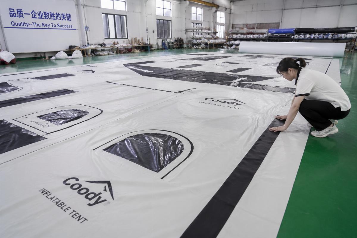 Custom printed PVC inflatable tent fabric laid out for quality inspection