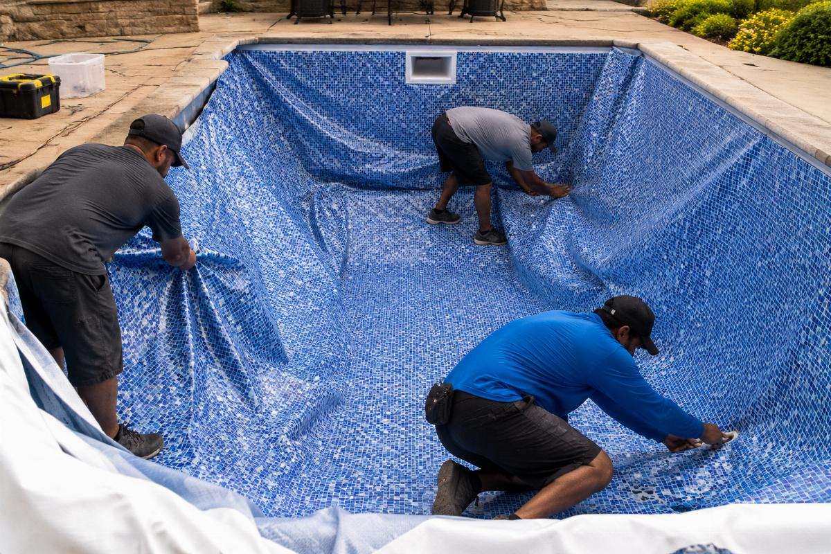 Installation team adjusting a poorly fitted pool liner on site