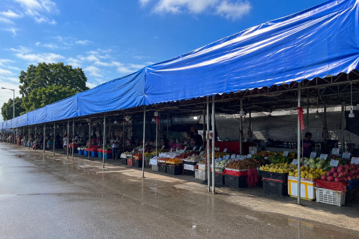 Installed PVC canopy tarpaulin covering a row of outdoor market stalls